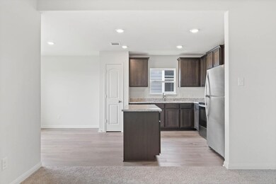 Kitchen featuring dark brown cabinets, stainless s