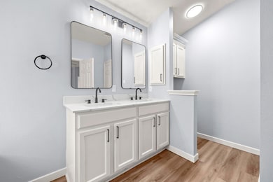 Full bathroom featuring double vanity and wood fi