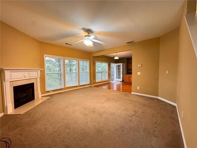 Unfurnished living room with light colored carpet, a fireplace, and ceiling fan