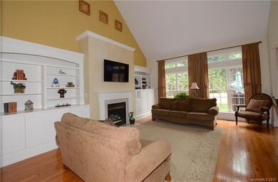 Great room has vaulted ceiling, hardwoods, built- 