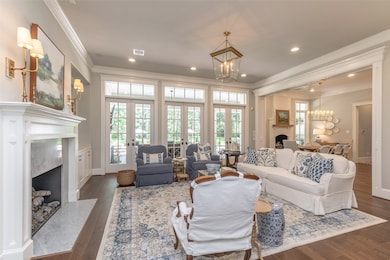 Family room with Wall of French doors for entertaining and accessing out door living area! Lots of natural lighting!R Real Wood floors throughout! Marble fireplace!
