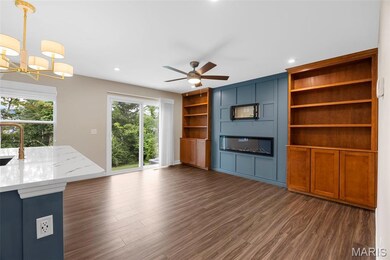 Unfurnished great room featuring dark wood finished floors, a sink, a ceiling fan, recessed lighting, and a chandelier