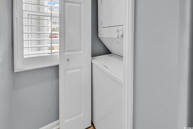 Washroom featuring stacked washer and dryer and laundry area