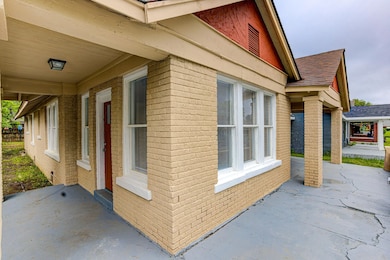 View of home's exterior with brick siding and roof with shingles