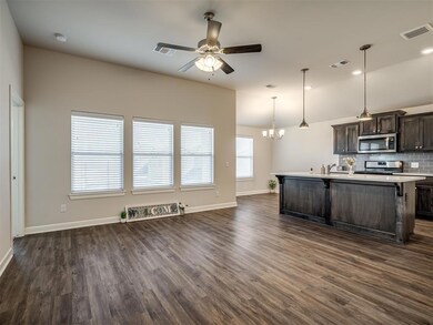 Kitchen with dark brown cabinets, hanging light fi