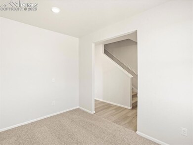 Empty room with stairway, light colored carpet, an