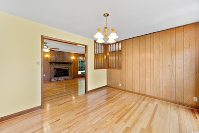 Spare room featuring wooden walls, baseboards, a f