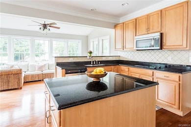 The kitchen is HUGE, and features hardwood flooring, wood cabinetry, granite countertops, tile backsplash, and a center island.