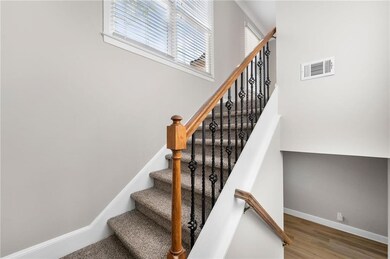 Stairway with visible vents, baseboards, and wood 
