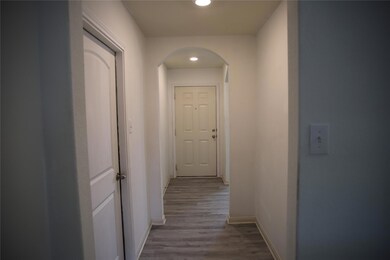 Hall featuring arched walkways, baseboards, wood 