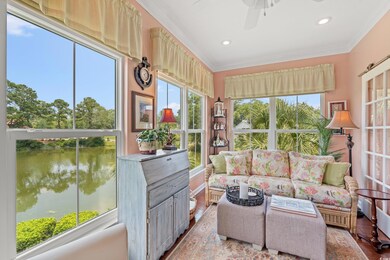 Sunroom featuring a water view, ornamental molding, wood finished floors, and recessed lighting