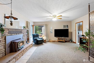 Very comfortable living room with woodstove fireplace. Opening on the right leads into the kitchen.