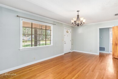 Empty room with a notable chandelier, light wood-t