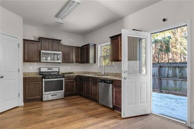 Kitchen with light stone countertops, sink, hardwo