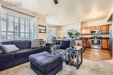 Living area with a ceiling fan and light wood-styl