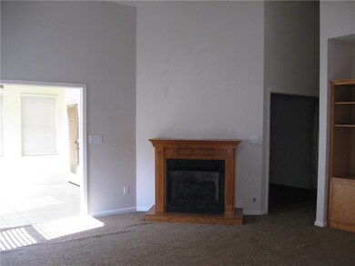 Gas fireplace in great room with vaulted ceiling and ceiling fan.