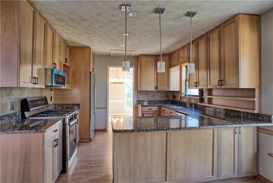 Kitchen with a peninsula, light wood-type flooring