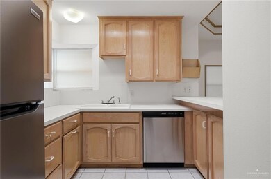 Kitchen featuring light tile patterned floors, appliances with stainless steel finishes, sink, and light brown cabinetry