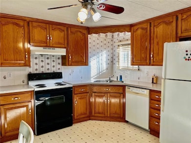 Kitchen featuring white appliances, brown cabinets, and light floors