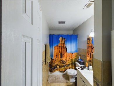 Bathroom with vanity, toilet, tile patterned floor