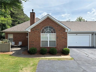 View of front facade with a chimney, asphalt drive