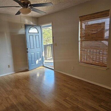 Foyer featuring a textured ceiling, a ceiling fan, and wood finished floors