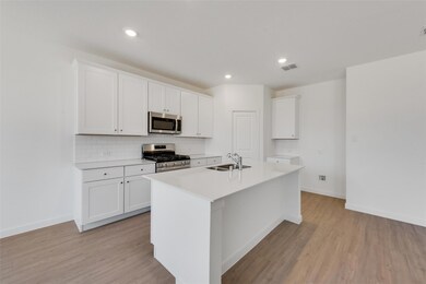 Kitchen featuring sink, a center island with sink,