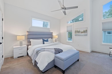 Bedroom featuring multiple windows, light carpet,