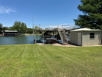 Dock with a lawn, a water view, boat lift, and st