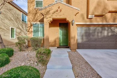 View of exterior entry with a garage, driveway, an