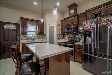 Kitchen with appliances with stainless steel finishes, a sink, light countertops, light tile patterned flooring, and recessed lighting