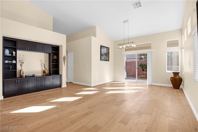 Unfurnished living room featuring light wood finished floors and a chandelier