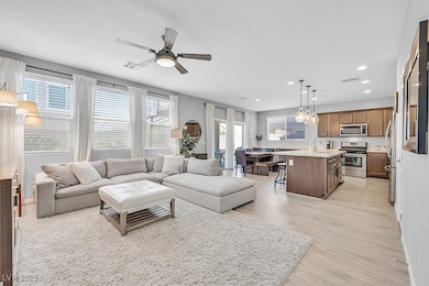 Living room with light wood finished floors, recessed lighting, and a ceiling fan