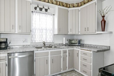 Kitchen with tasteful backsplash, sink, and dishwa