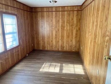 Empty room with hardwood / wood-style floors and w