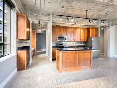 Kitchen with brown cabinets, dark countertops, an