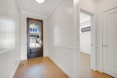 Welcoming front entry showcasing gorgeous front door, crown molding, chair rail accents, access the 2nd bedroom or home office and front closet.