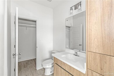 Bathroom featuring toilet, vanity with extensive cabinet space, and hardwood / wood-style floors
