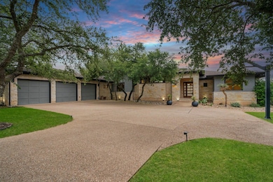 View of front of property with stone siding, driveway, and a yard