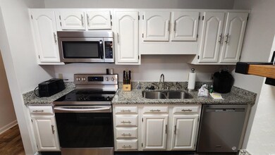 Kitchen featuring white cabinetry, appliances with