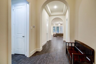 A vaulted entry with high arches and tray ceiling gives a stunning view as you enter the home.