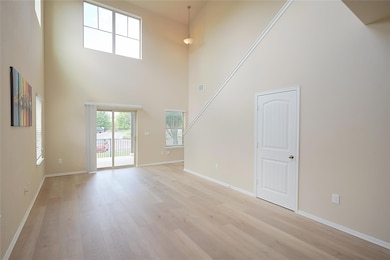 Unfurnished living room featuring a towering ceil