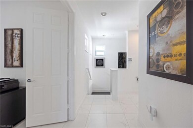 Hall with light marble finish floors and baseboards