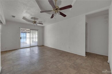 Spare room featuring tile flooring, ceiling fan, and a textured ceiling