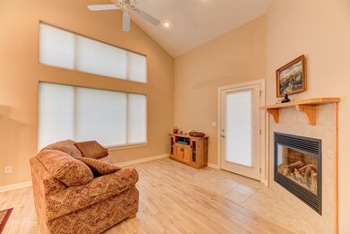 Sitting room with a fireplace, hardwood / wood-style flooring, high vaulted ceiling, and ceiling fan