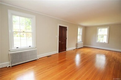 Large Great Room flooded with natural light, classic radiators, gleaming hardwood floors
