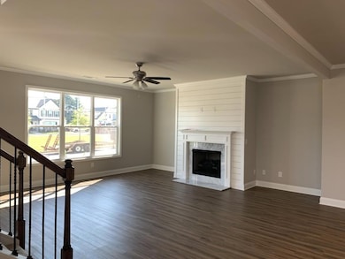 Unfurnished living room featuring a ceiling fan, d