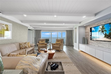 Living area featuring healthy amount of natural light, wood finished floors, and beamed ceiling