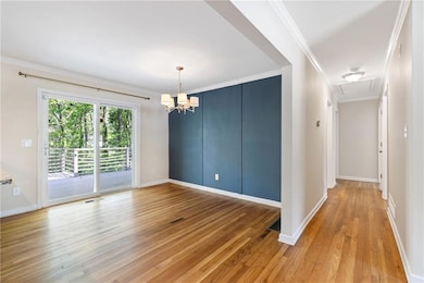 Empty room featuring attic access, light wood-styl