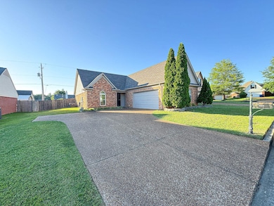 View of front facade with brick siding, driveway, a garage, and roof with shingles